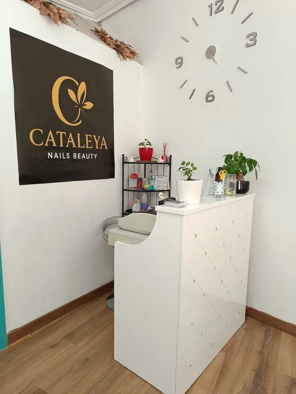 Una estación de salón de uñas blanca con un cartel de 