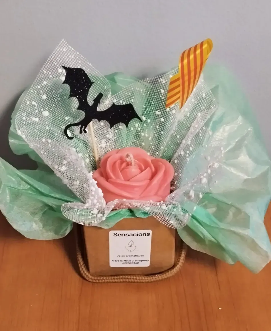 Cesta de regalo con una rosa rosa, tul menta, una mariposa negra y un detalle de rayas naranjas en una pequeña caja marrón.