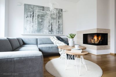 Minimalistisch eingerichtetes Wohnzimmer mit Kamin und großem Eck-Sofa
