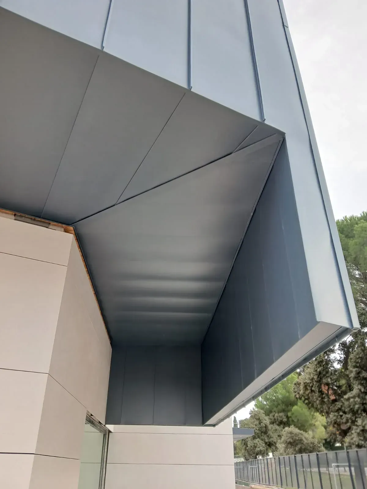 Un primer plano del tejado de un edificio con una valla al fondo.