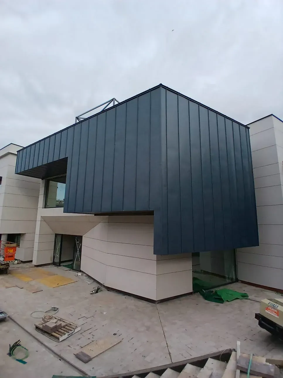 Se está construyendo un gran edificio con techo azul.