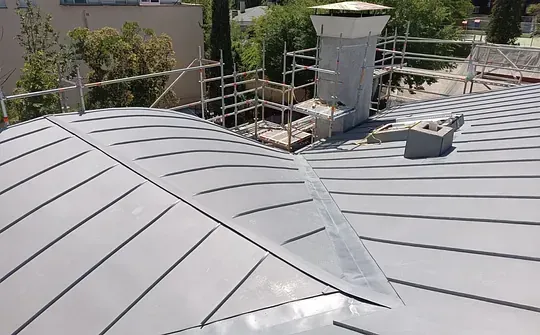 Un primer plano de un tejado con una chimenea.