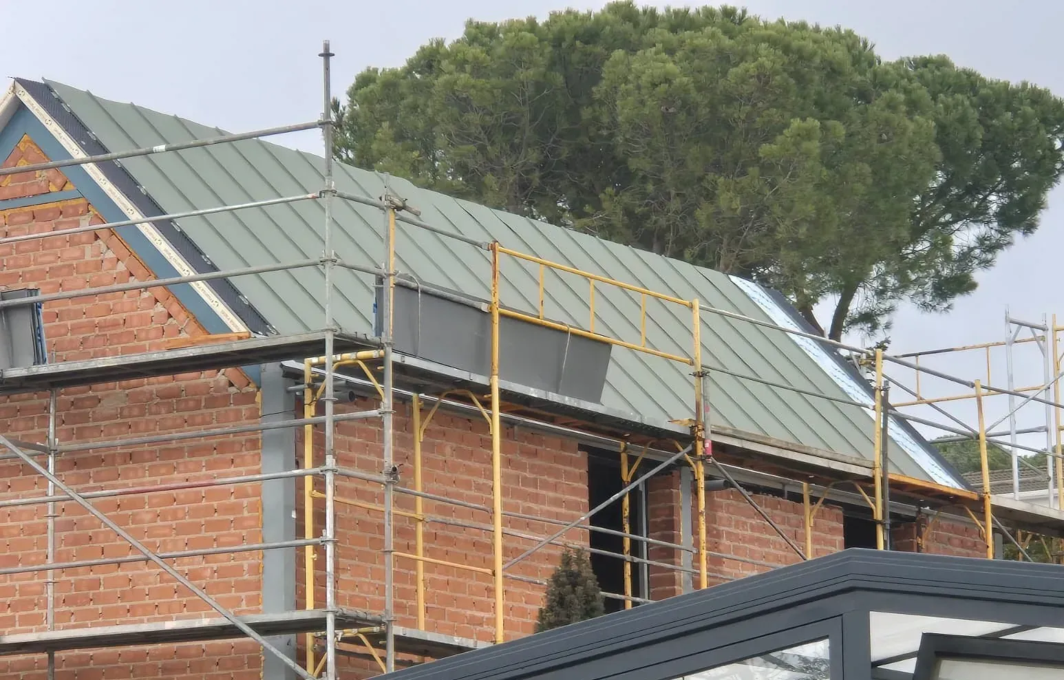 Un edificio de ladrillo en construcción con techo verde.