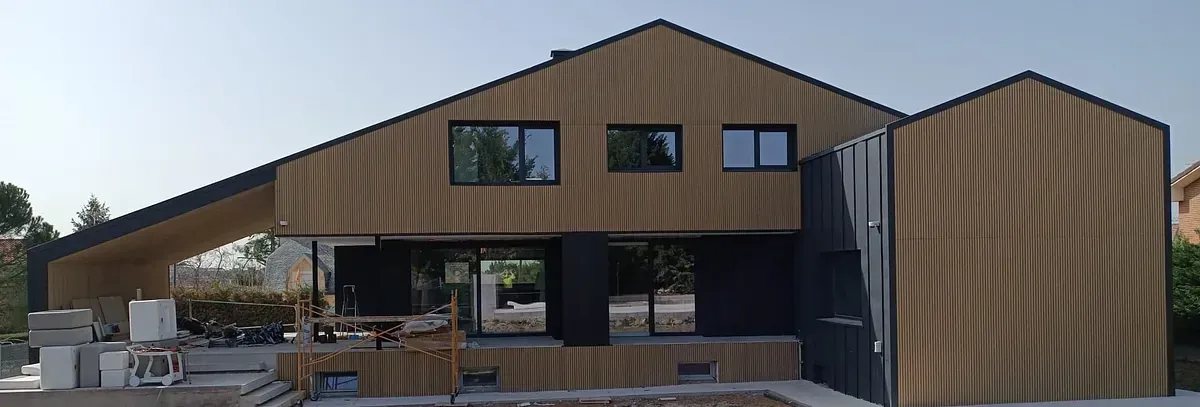 Se está construyendo una casa grande con muchas ventanas.