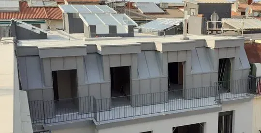 Un edificio con un balcón en la parte superior.