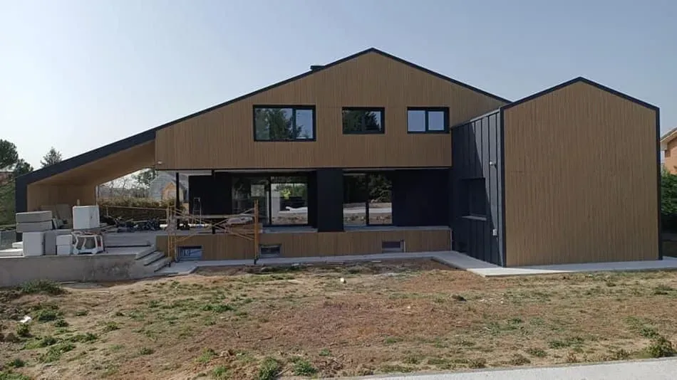 Se está construyendo una casa grande con muchas ventanas.