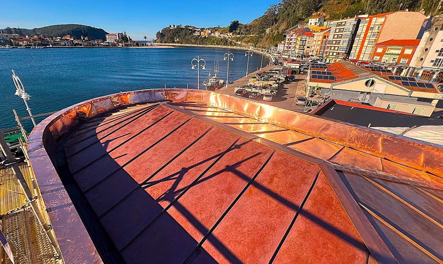 Un barco está atracado en un puerto con edificios al fondo.