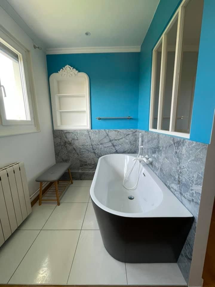 Salle de bains rénovée avec un mur bleu