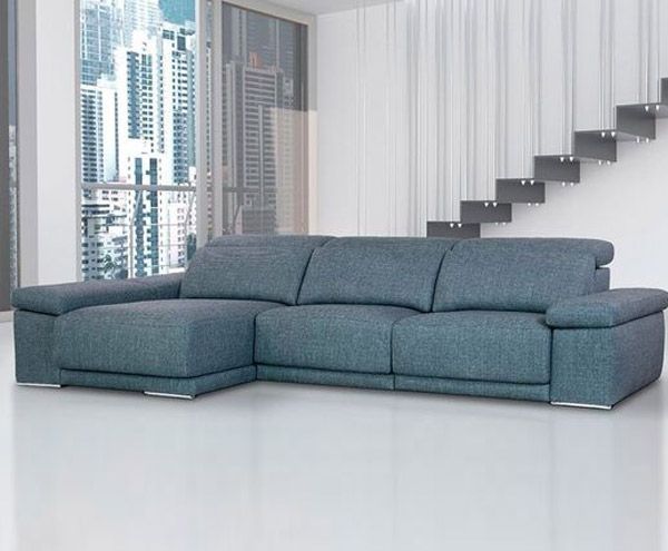 Un sofá seccional azul está en una sala de estar al lado de una escalera.