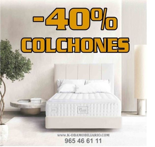 Una mujer está sentada en una cama mirando un colchón.