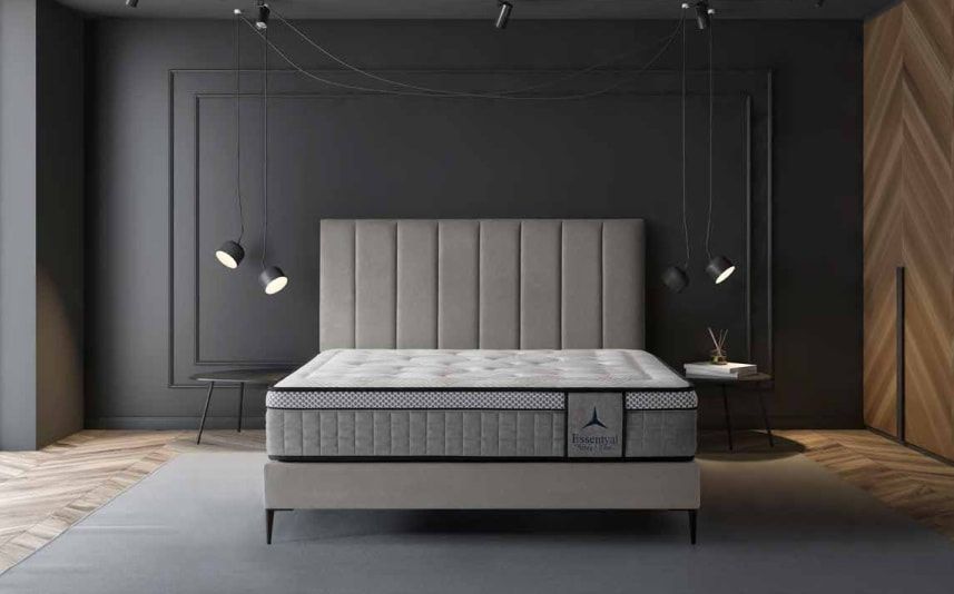 Una cama con un colchón y un cabecero en un dormitorio.