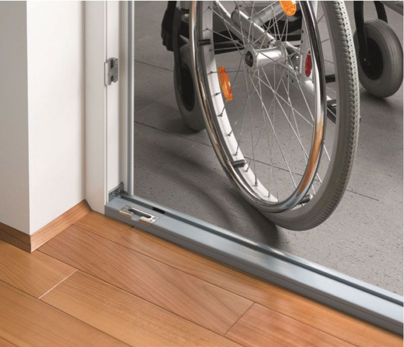 Ein Rollstuhl wird durch eine Tür geschoben