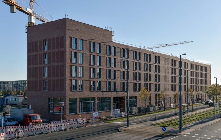 Ein großes Backsteingebäude im Bau mit einem Kran im Hintergrund.