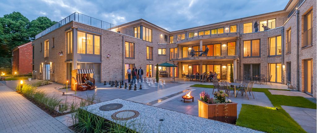 Ein großes Gebäude mit vielen Fenstern ist nachts beleuchtet.