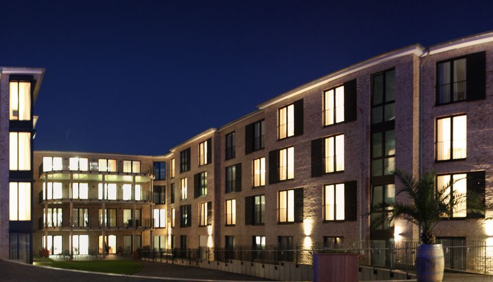 Ein großes Gebäude mit vielen Fenstern ist nachts beleuchtet