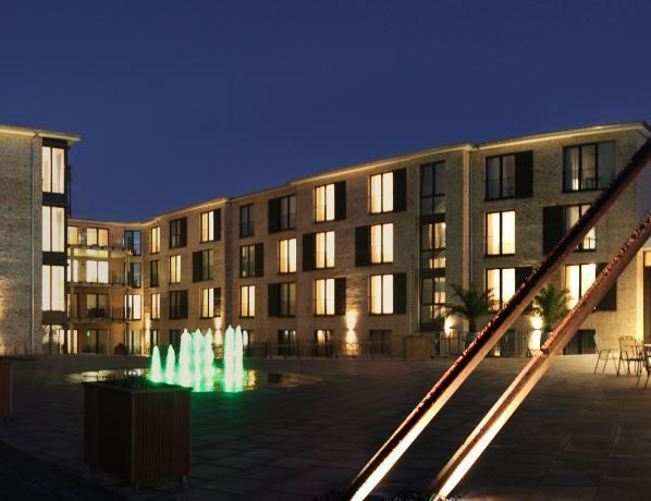 Ein großes Gebäude mit einem Brunnen davor