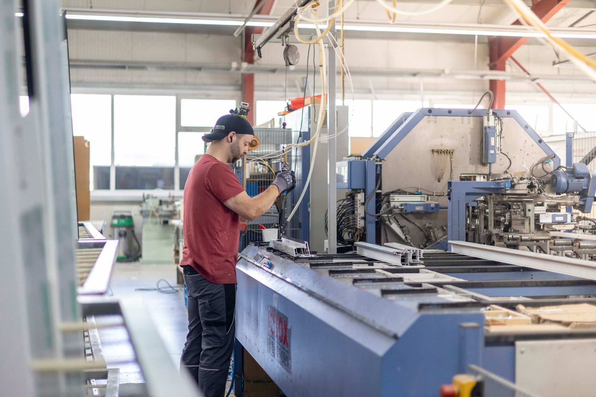Ein Mann arbeitet in einer Fabrik an einer Maschine.