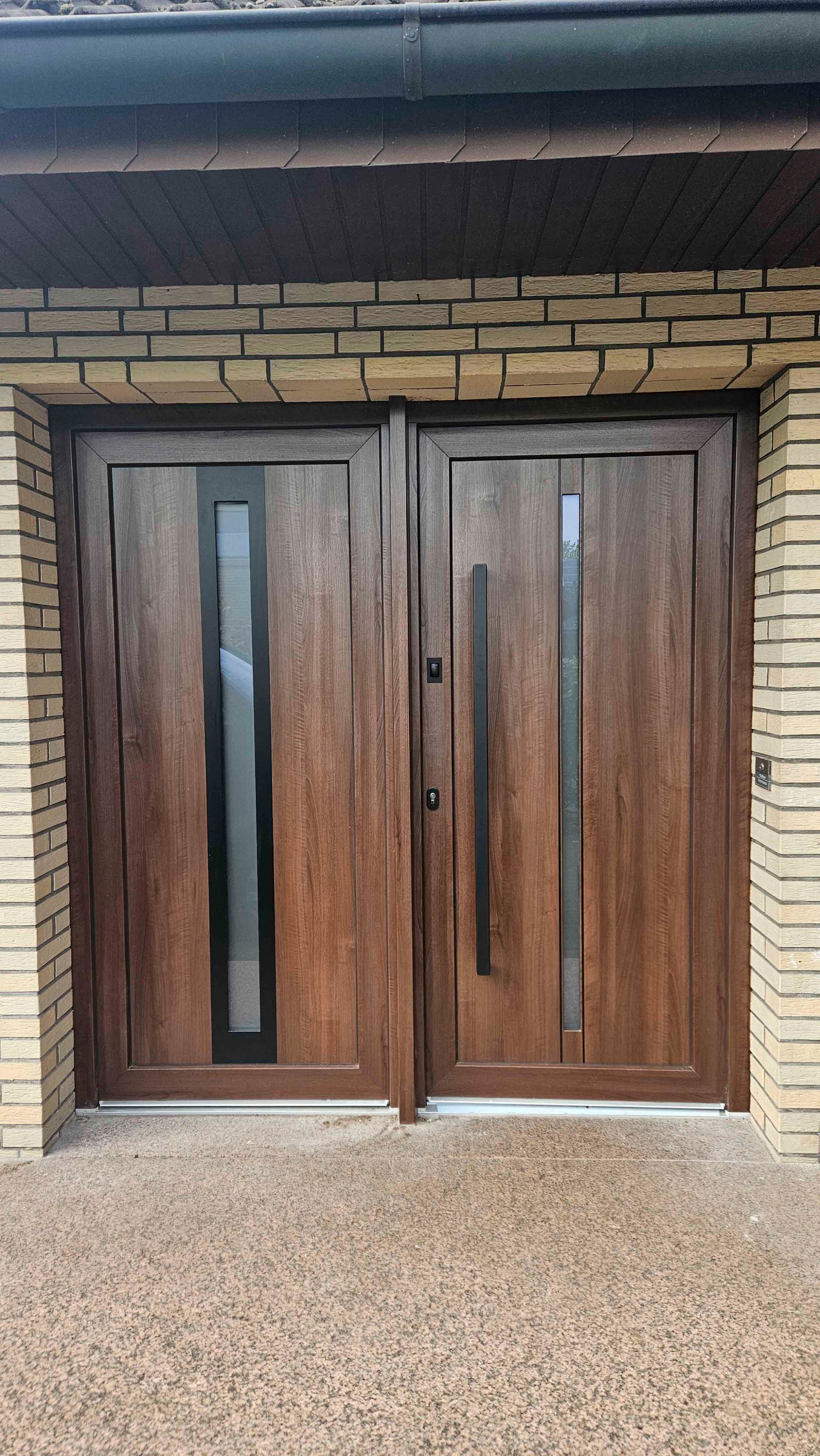 Ein Paar hölzerne Garagentore an einem Backsteingebäude.