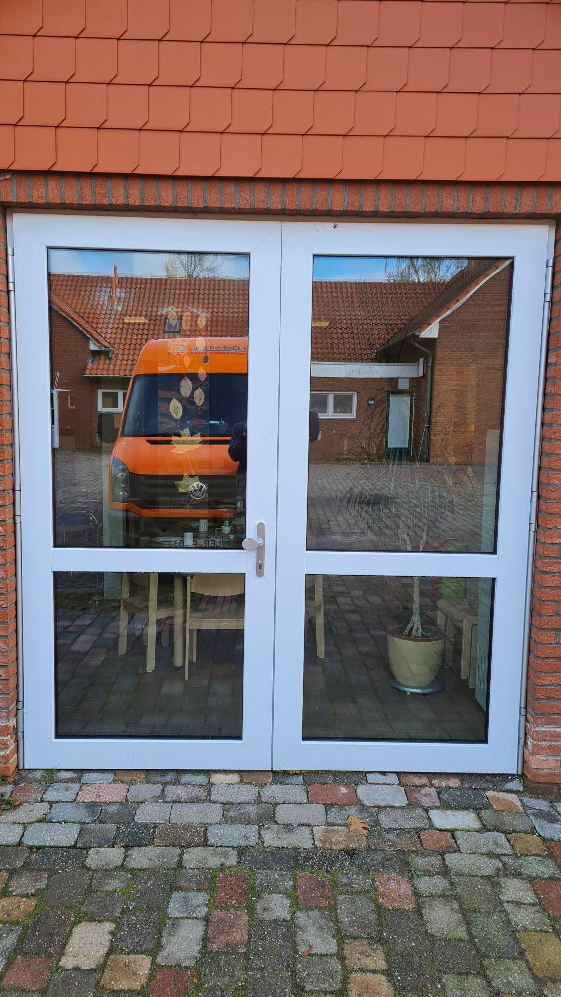 Ein weißer Lieferwagen steht vor einem Backsteingebäude.