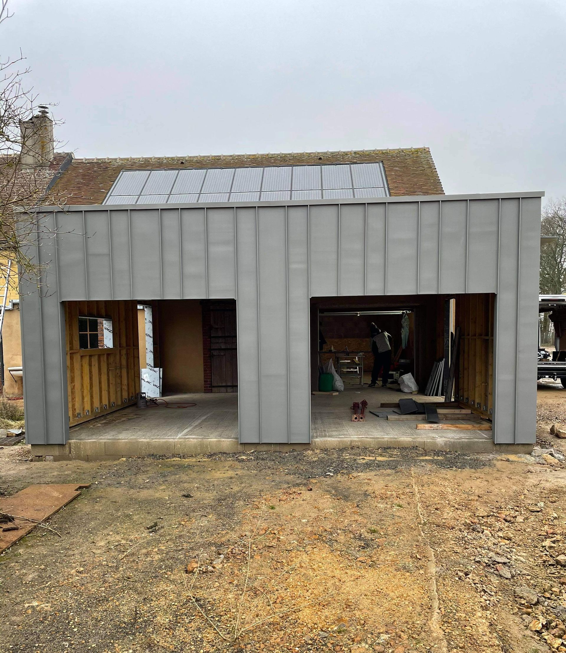 Façade d'un garage en travaux avec bardage métallique