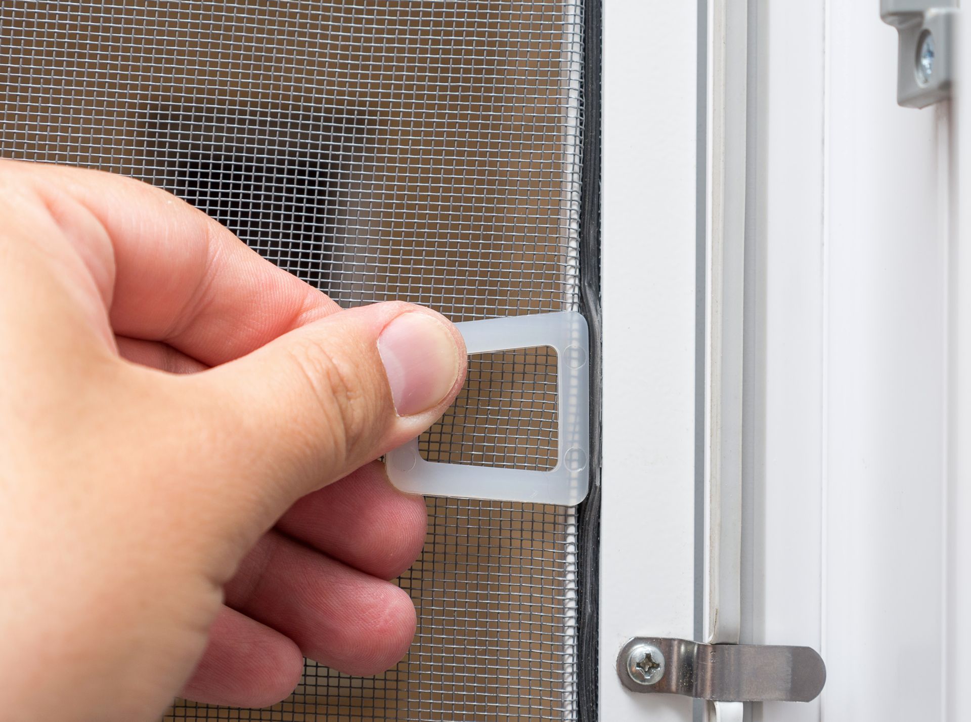 Professionnel posant une moustiquaire à une fenêtre