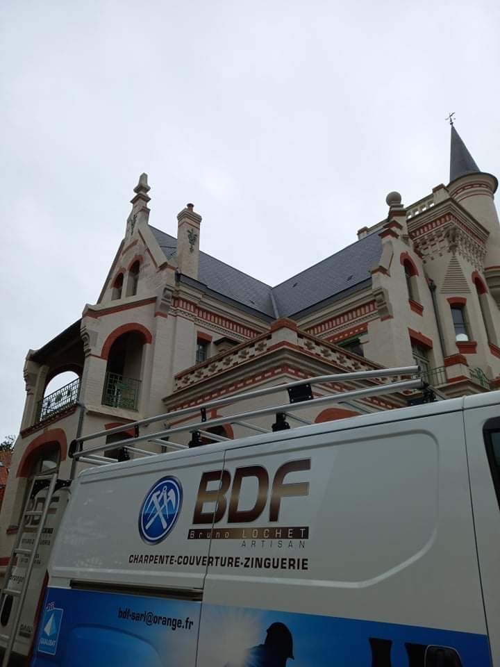 Camion de l'entreprise B.D.F. devant un très vieil édifice