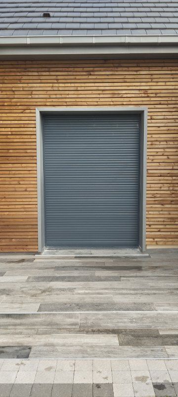 Store d'une porte-fenêtre d'une maison avec bardage en bois