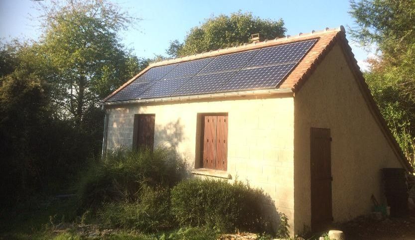 Une petite maison avec des panneaux solaires