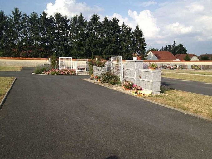 Allée pavée menant à l'entrée d'un cimetière.