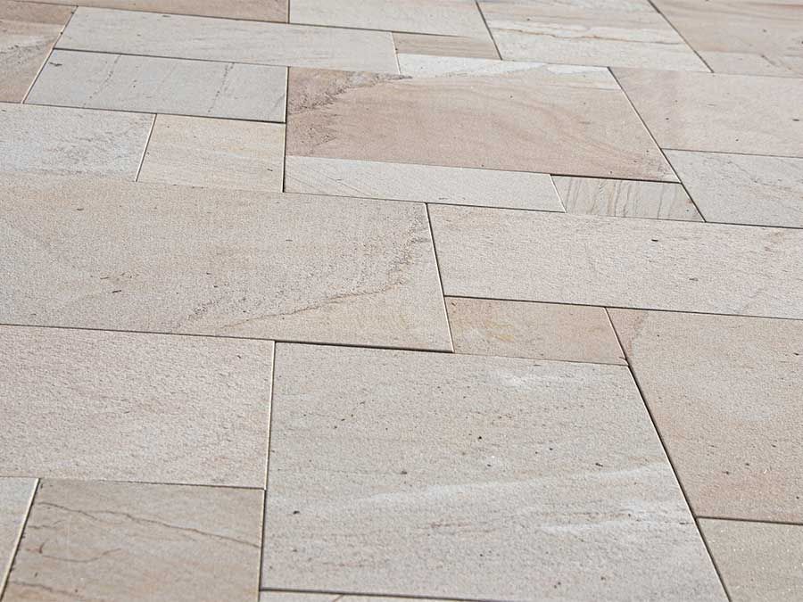 Dallage en pierre beige clair avec des carreaux rectangulaires disposés en quinconce
