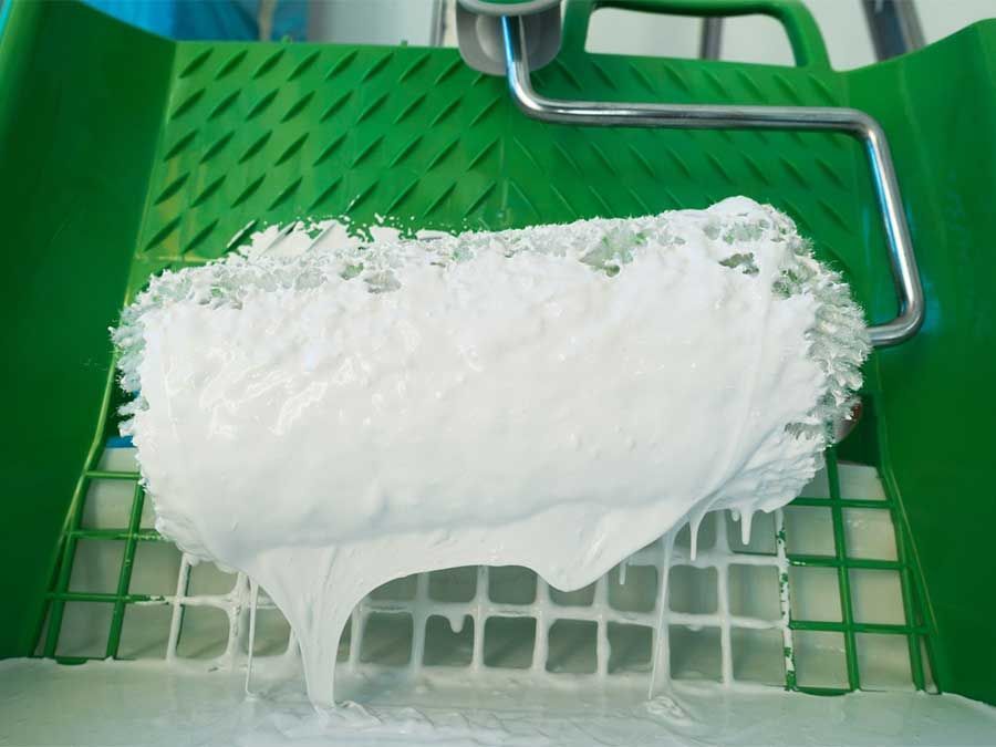 De la mousse blanche déborde d'un panier de supermarché vert