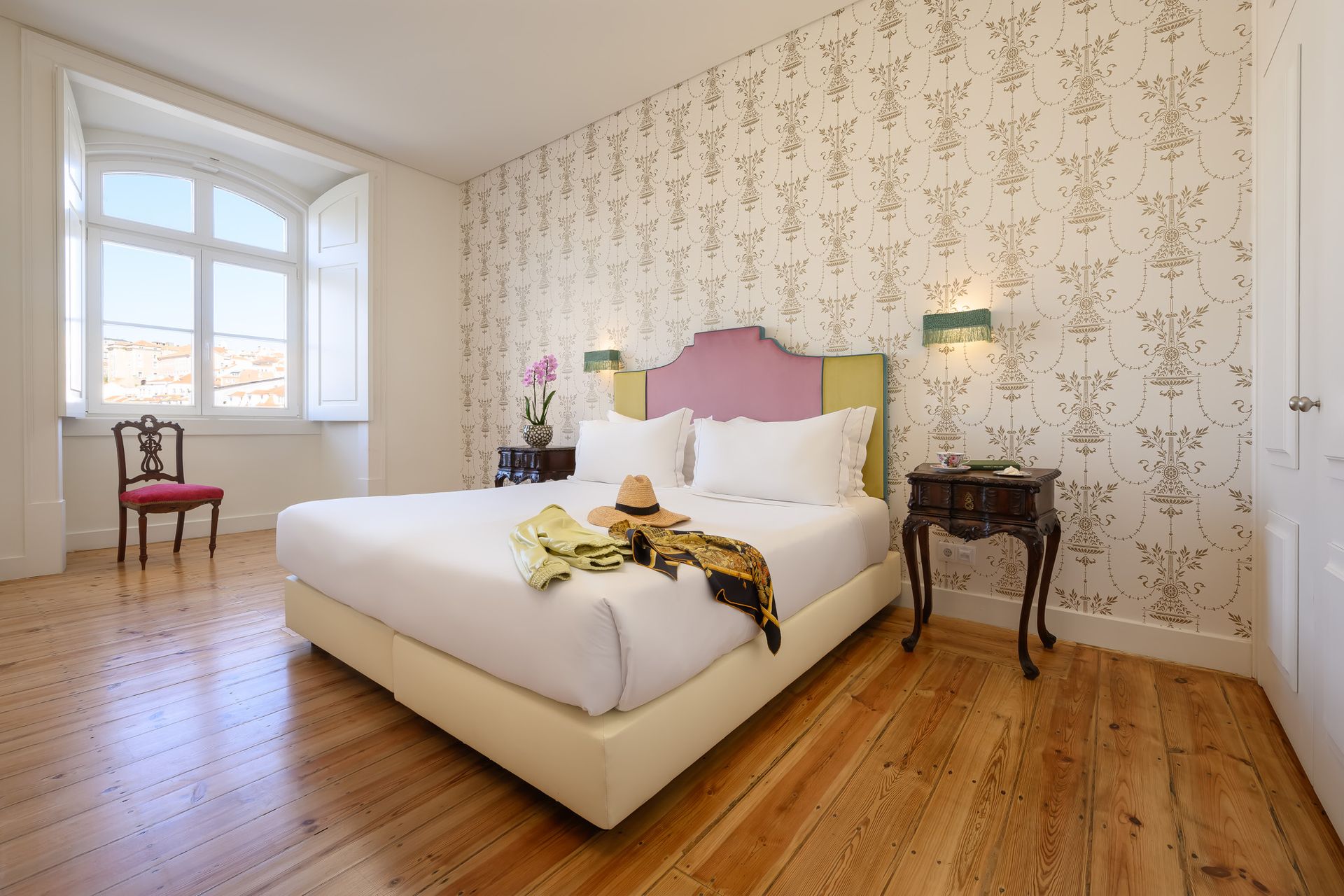 Bedroom with a bed, wallpaper, a window, and wood floor.