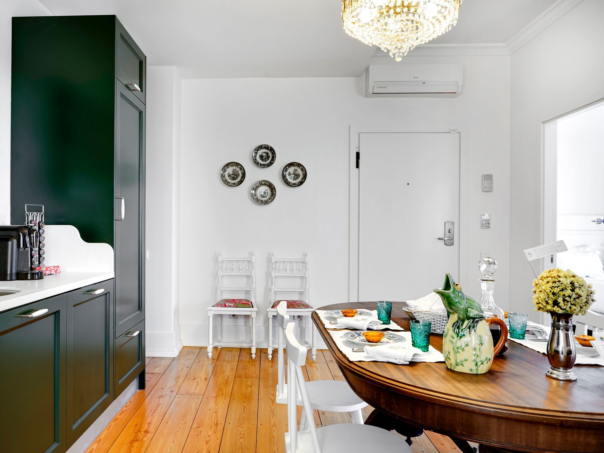 Modern kitchen with green cabinets and dining area in a spa deluxe two-bedroom apartment.