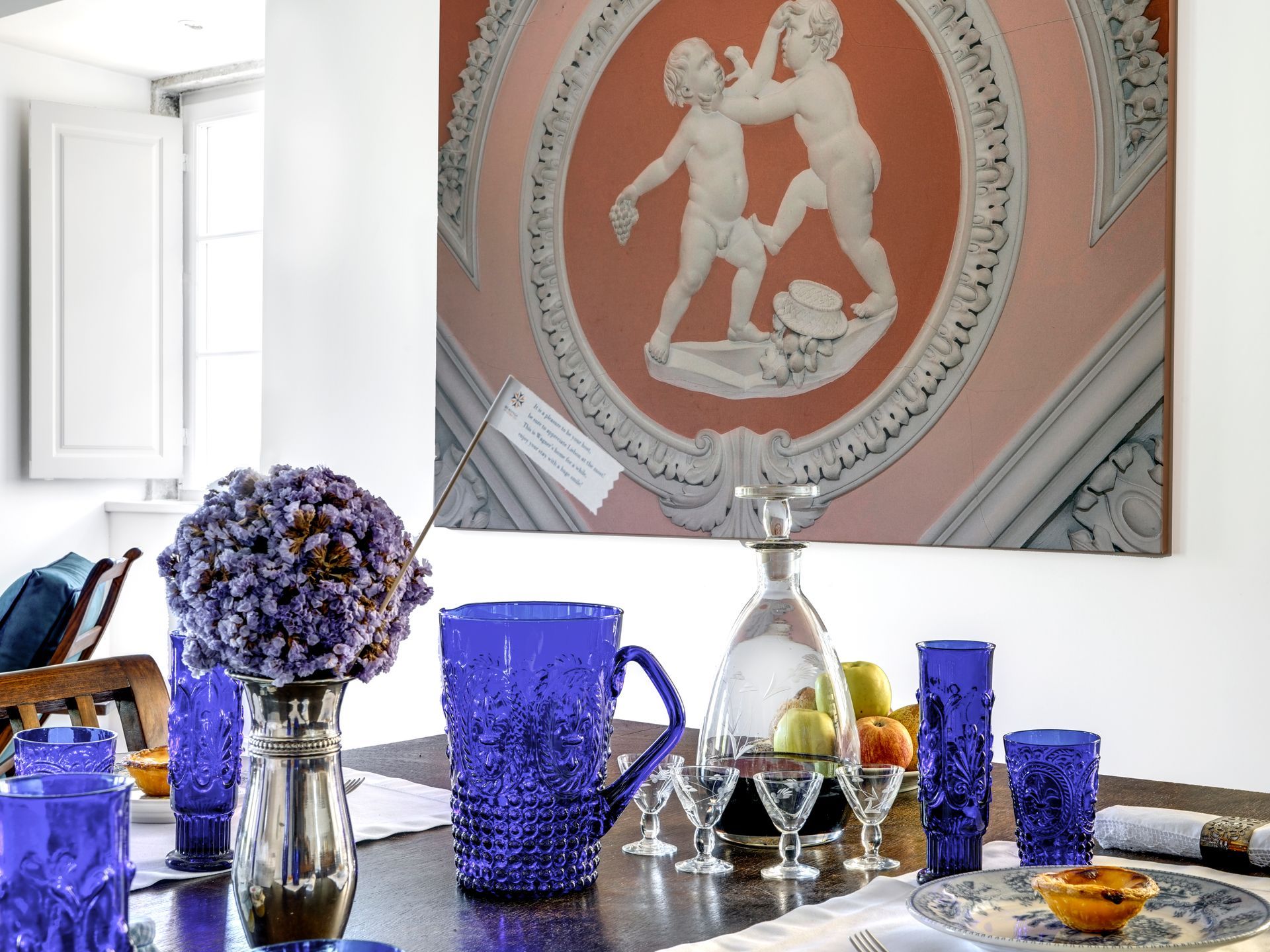 Decorative vase and glassware in a premium one-bedroom apartment with a beautiful wall mural.