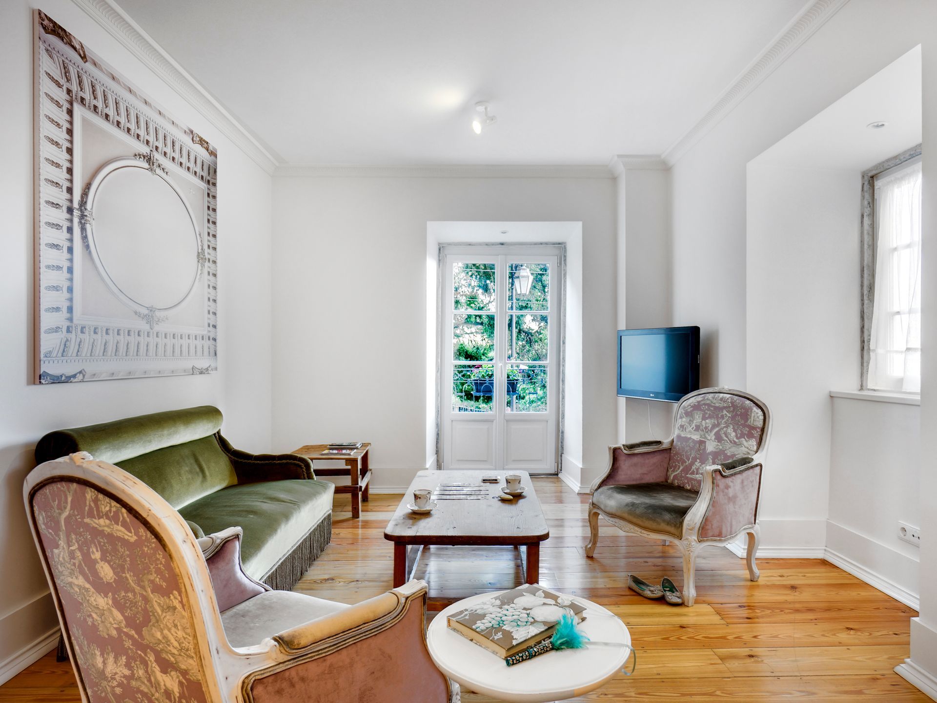 Cozy living area with green seating and natural light in a deluxe two-bedroom apartment.