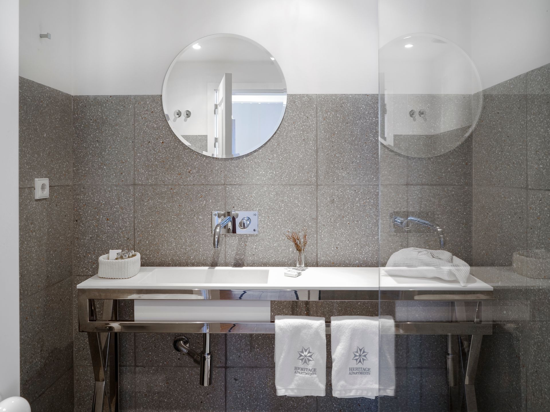 Modern bathroom with a large mirror and stylish gray tiles in a spa penthouse two-bedroom apartment.