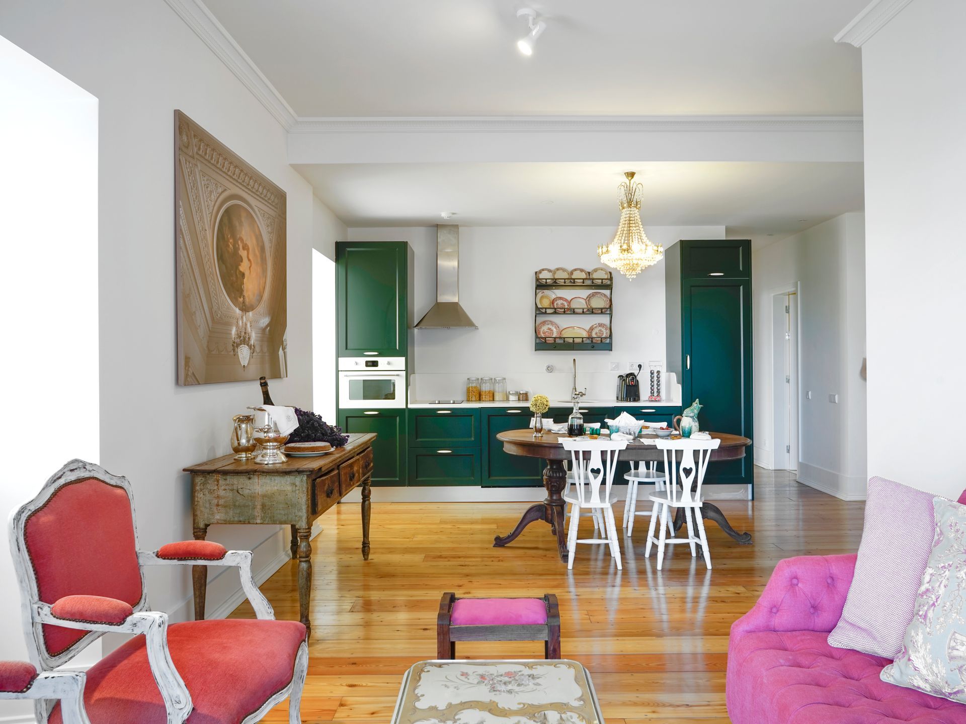 Modern kitchen and dining area in a spa deluxe two-bedroom apartment with green cabinets.