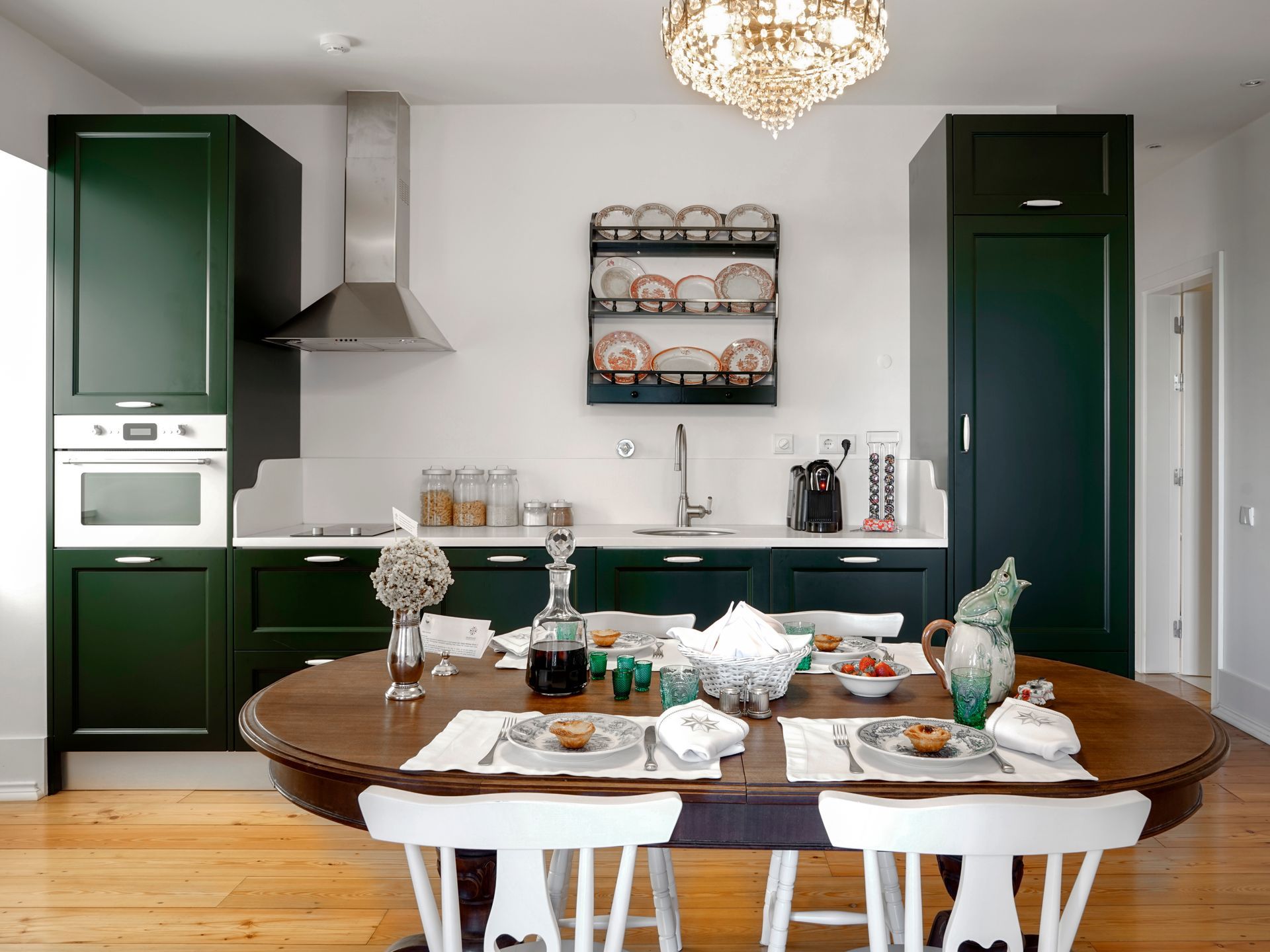 Modern kitchen with green cabinets and stylish dining setup in a spa deluxe two-bedroom apartment.