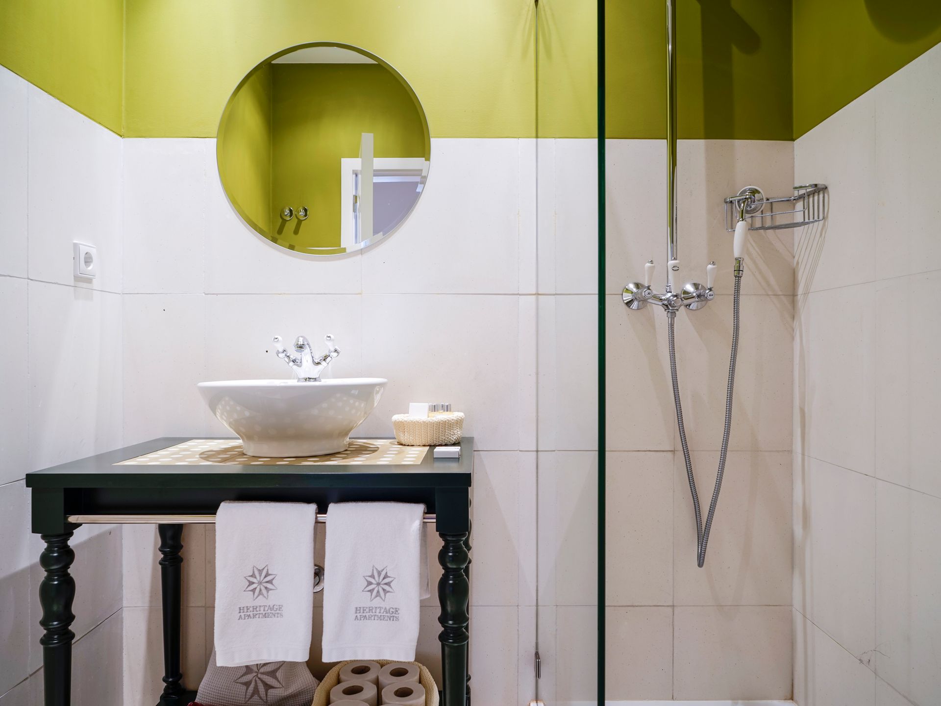 Modern bathroom with green accent wall, sink, and shower in a spa deluxe two-bedroom apartment.