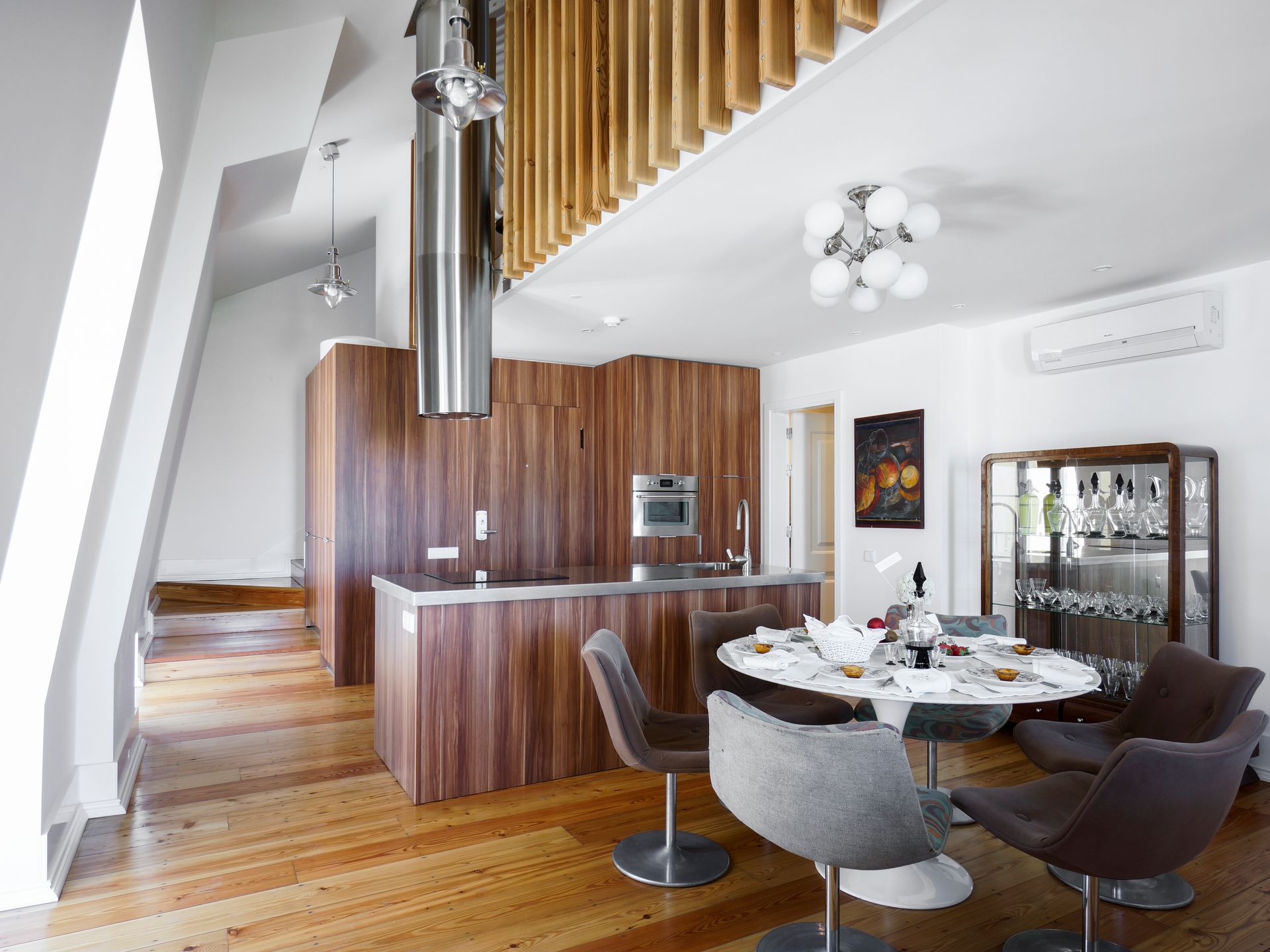 Open-plan living area with modern kitchen and dining table in a spa penthouse two-bedroom apartment.
