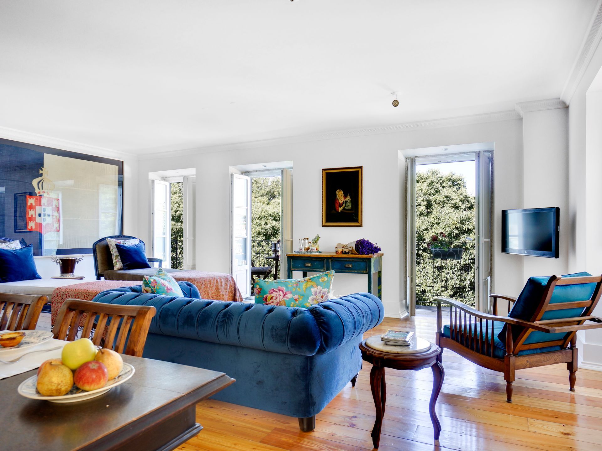 Bright living room in a spa premium one-bedroom apartment with cozy seating and large windows.