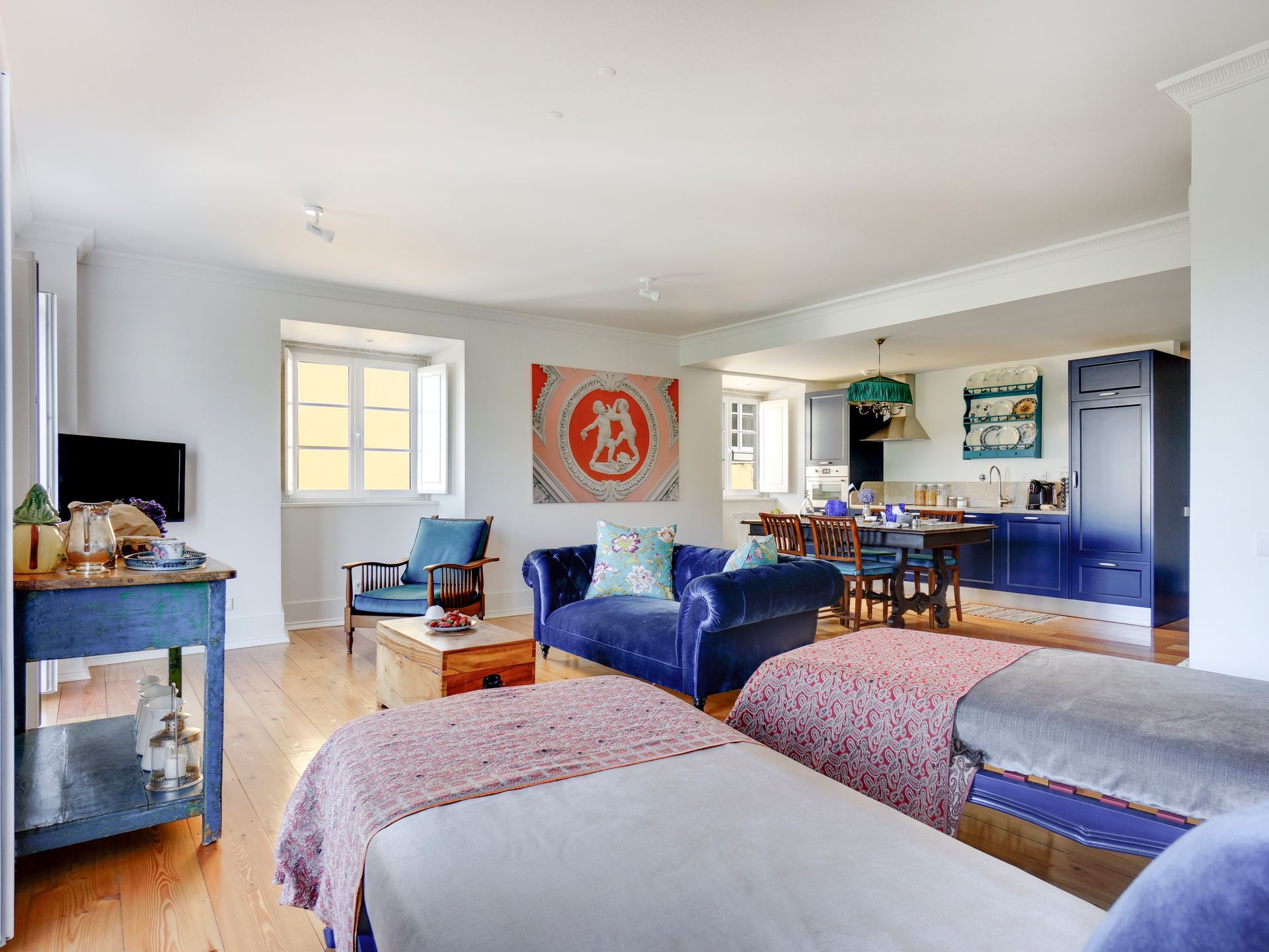 Open living and dining area in a spa premium one-bedroom apartment with colorful artwork and modern kitchen.