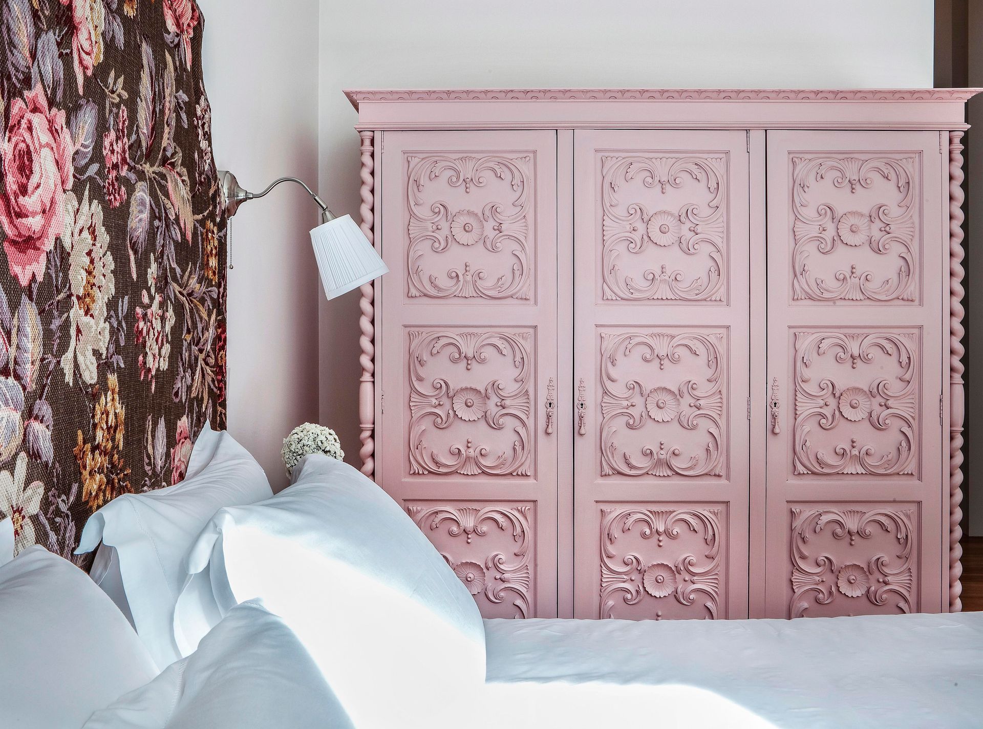 Antique pink wardrobe in a deluxe one-bedroom apartment with floral details.