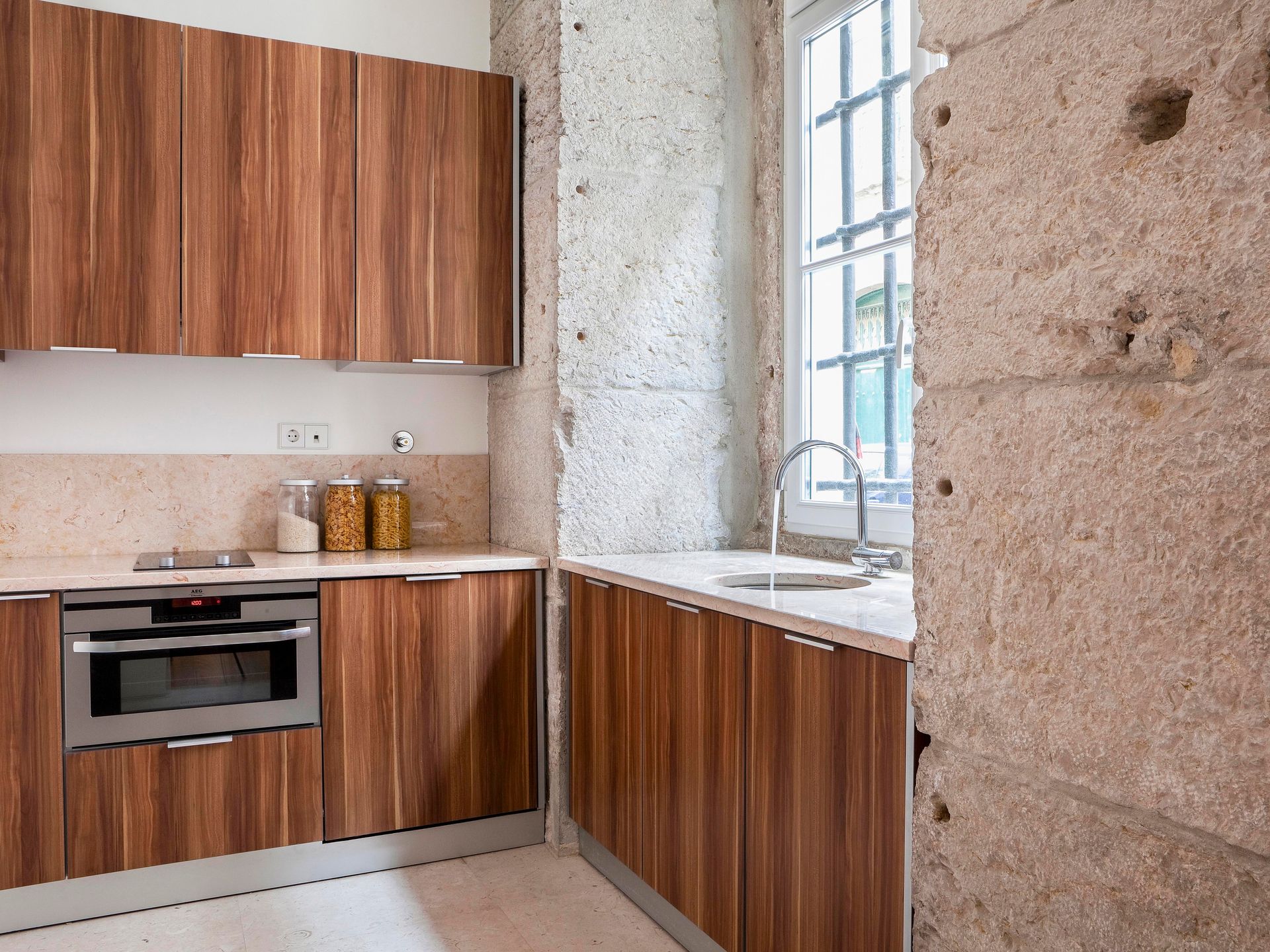 Modern kitchen in a deluxe one-bedroom apartment with wooden cabinetry and stainless steel appliances.