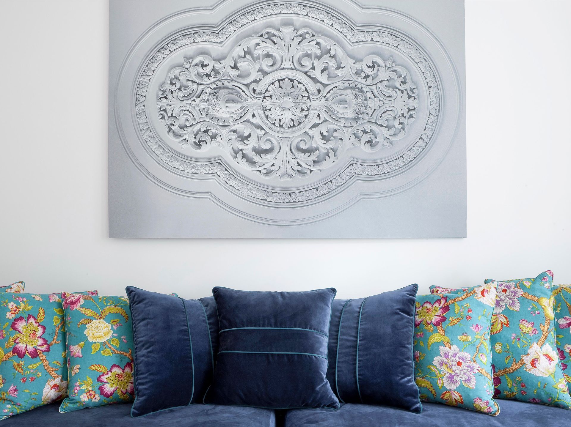 Living room with a modern wall art and colorful cushions in a deluxe one-bedroom apartment.