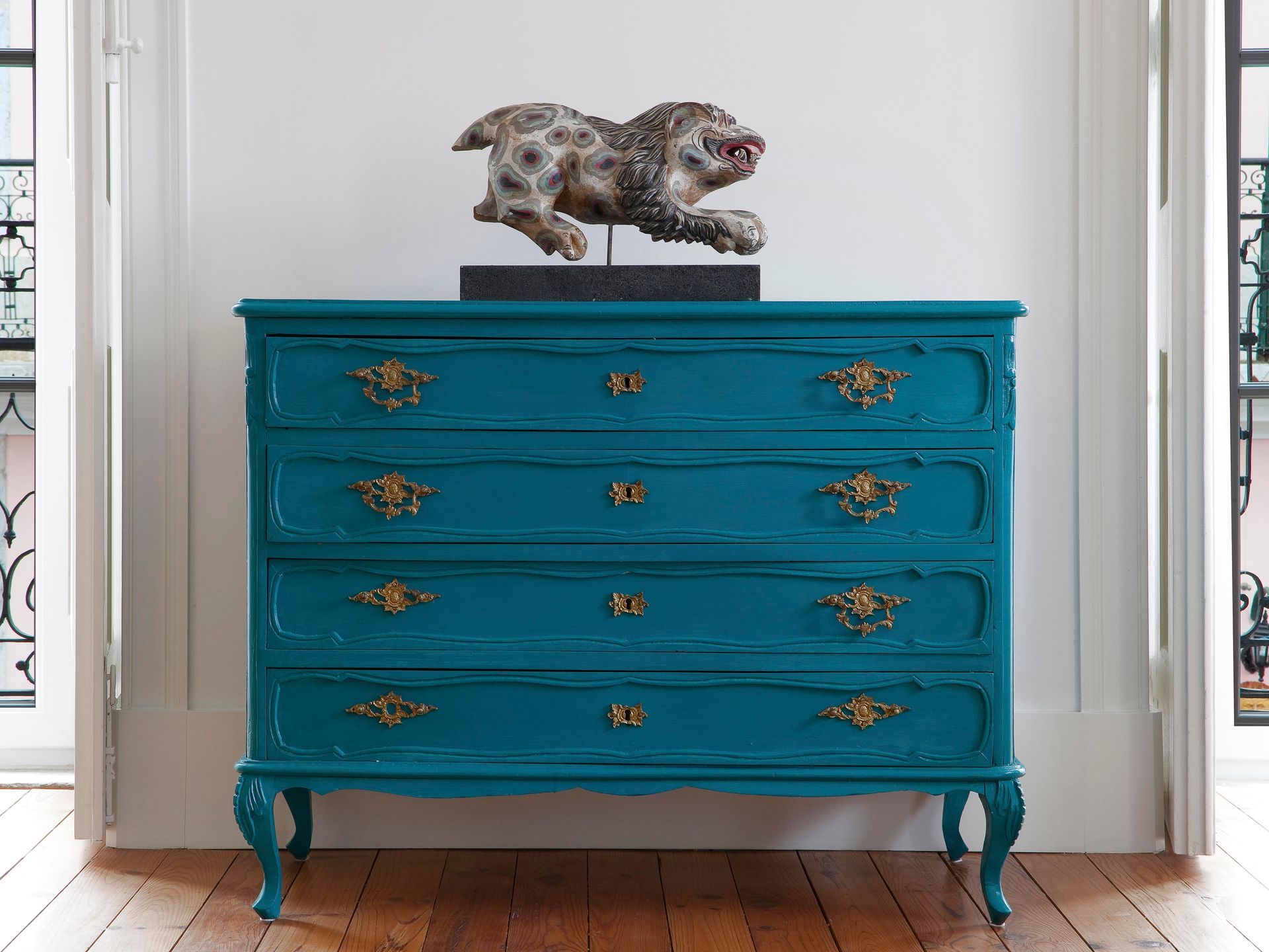 Vintage turquoise dresser with decorative sculpture in a duplex two-bedroom apartment