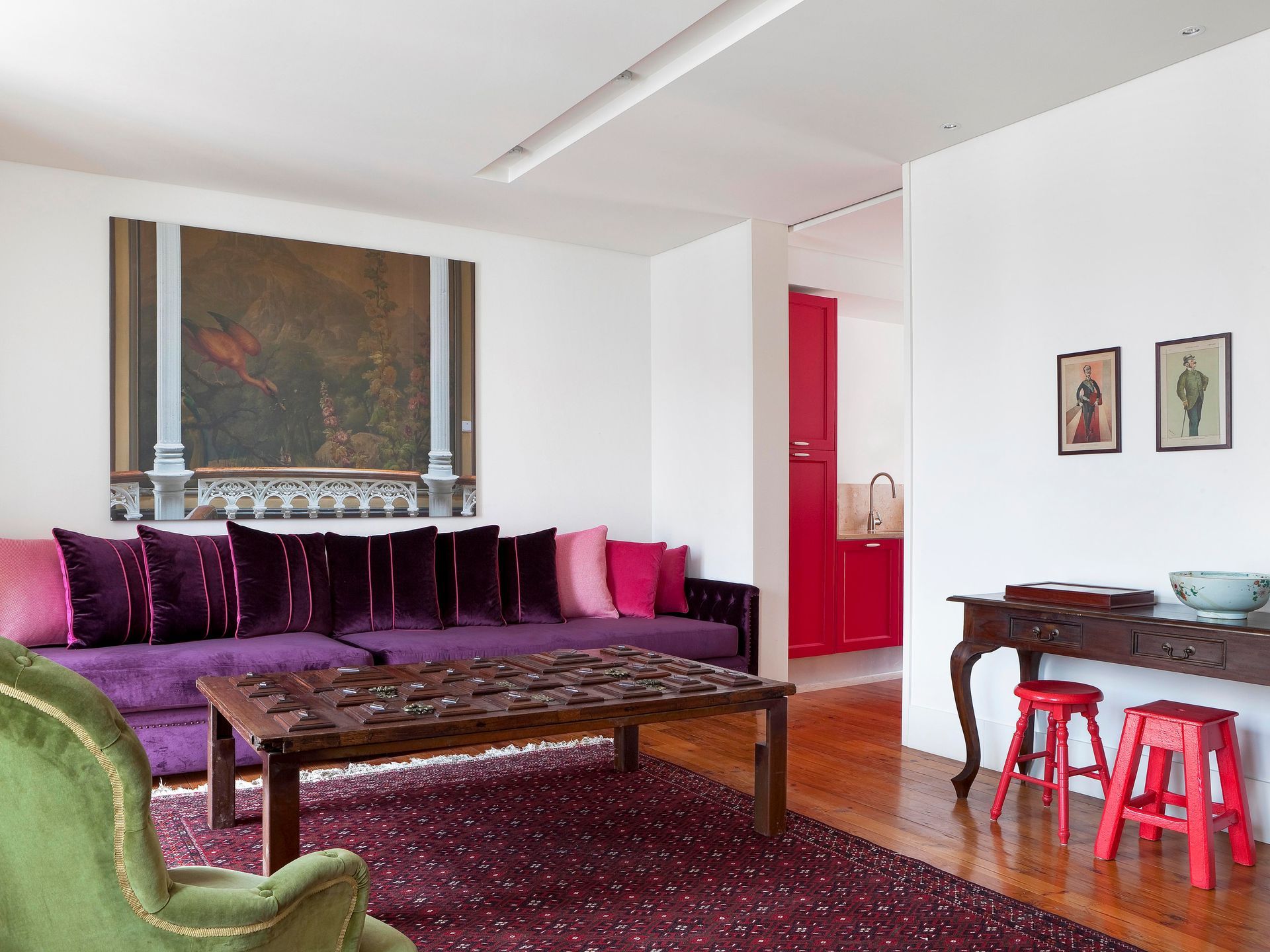 Stylish living room in a duplex one-bedroom apartment with a large purple sofa and colorful cushions.