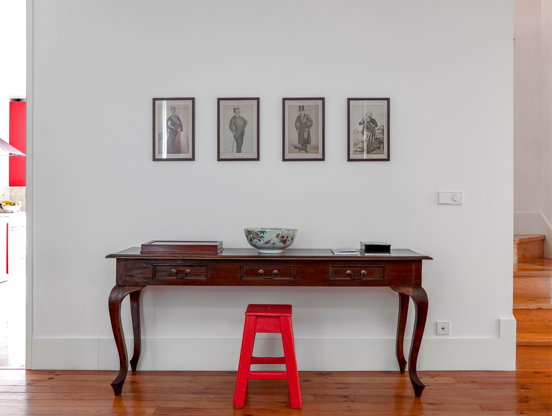 Classic console table with framed artwork and decorative items in a duplex one-bedroom apartment.