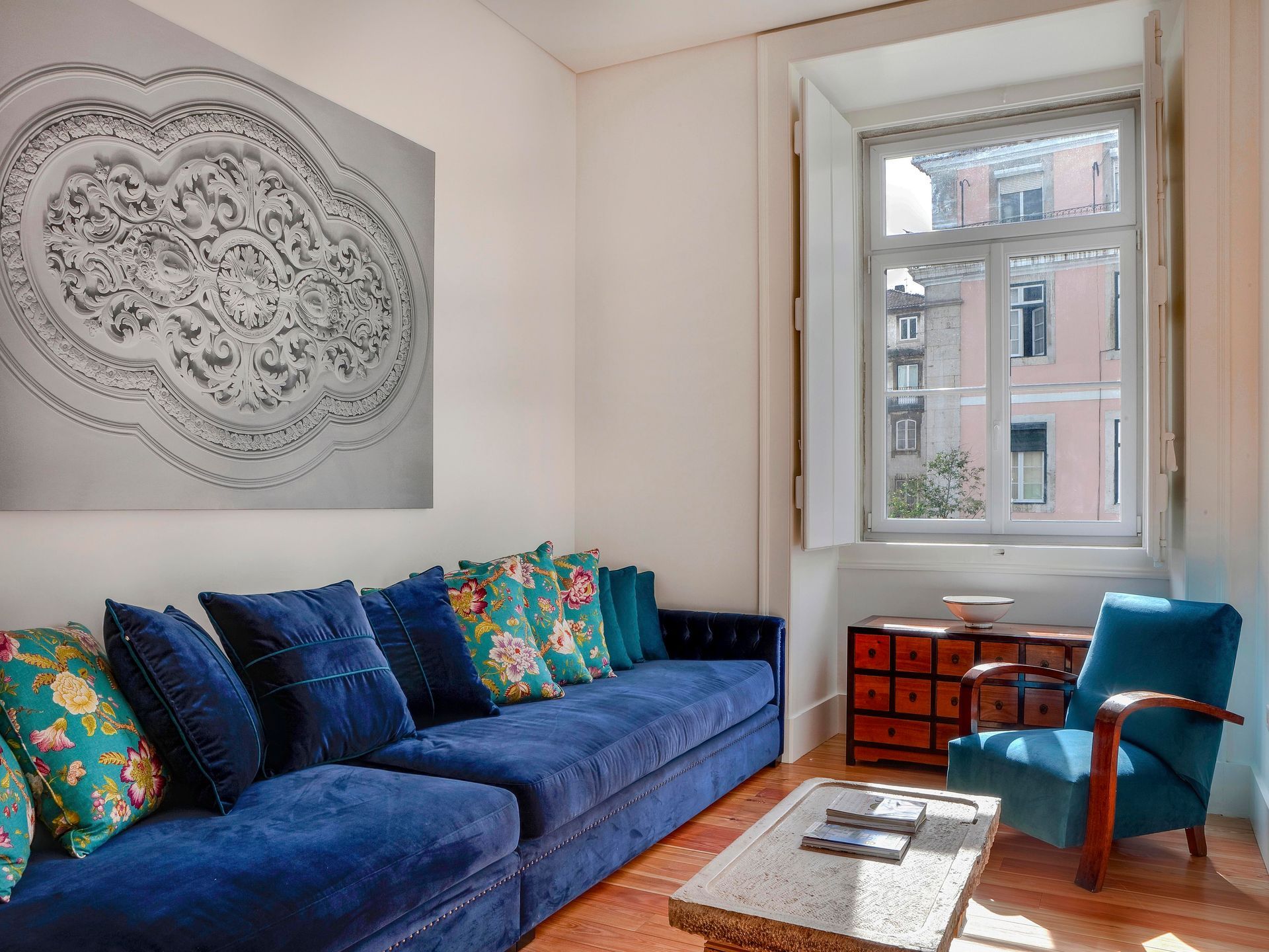Cozy seating area with blue sofa and decorative cushions in a deluxe one-bedroom apartment.