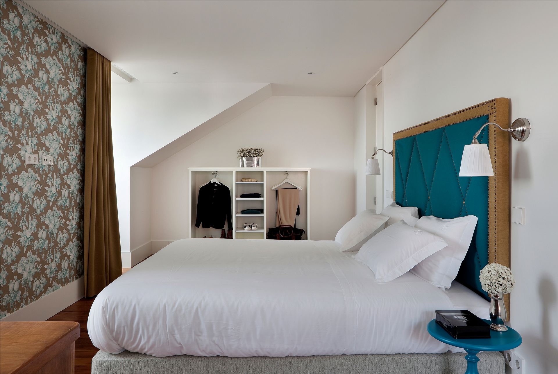 Bright bedroom in a duplex two-bedroom apartment with a teal headboard and cozy decor.